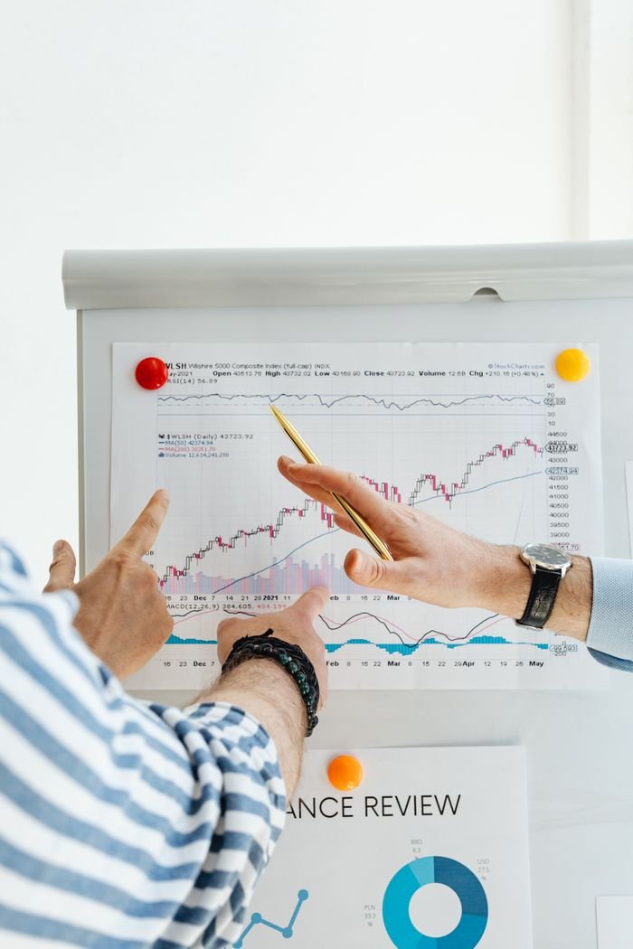 The Art of Drawing Readers In: Your attractive post title goes here Two people analyzing financial charts on a whiteboard during a business meeting.
